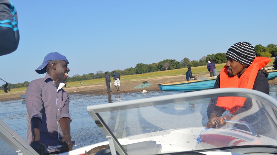 Chalumba Kachusi Simukoko og en fisker i båt på feltarbeid i en innsjø.