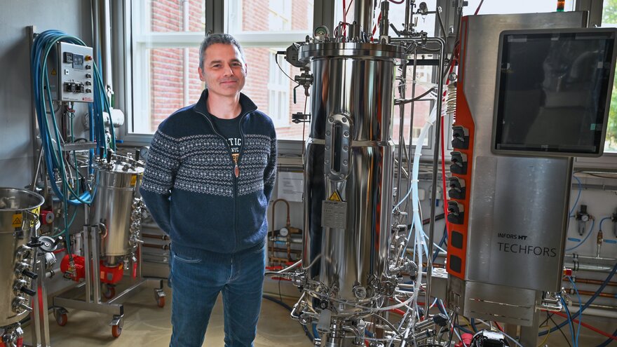 Svein Jarle Horn ved siden av pilotskala bioreaktoren (100 liter) som befinner seg på fakultet for kjemi, bioteknologi og matvitenskap ved NMBU. 
