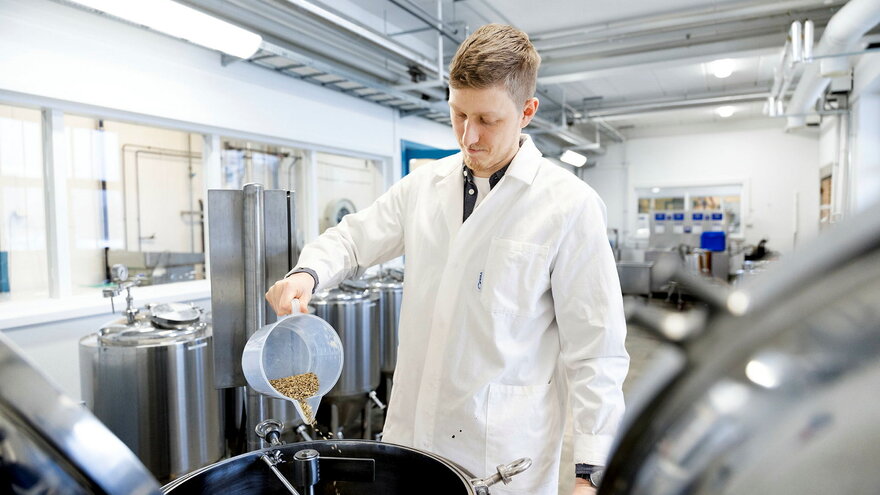 Tilsetning av malt til 60 L bryggemaskin på NMBU sin Matpiloten / Forsøksbryggeri som gir sukker som blir senere omdannet til alkohol av gjær. 

Addition of malt to the 60 L brewing system at NMBUs food pilot plant / experimental brewery which gives su