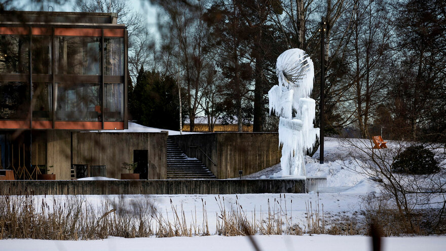 Carl Nesjar (1920-2005) Fontenen/skulpturen sto ferdig i 1971 ved Auditorium Maximum. Fontenen er en stålkonstruksjon som utnytter vannspillet i sommerhalvåret, og om vinteren dekkes den av istapper og krystaller. Carl Nesjar var maler, grafiker og bill