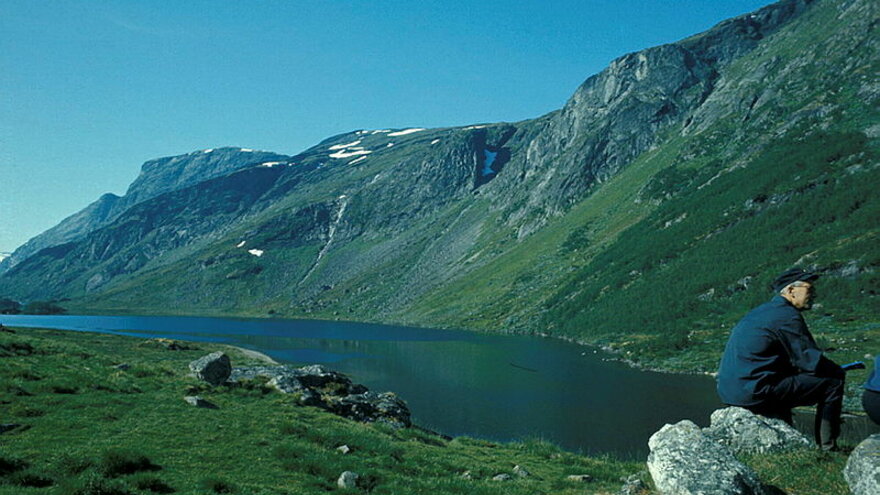 Aurland I in 1967: The river flowing in front of the mountain, a man sitting on a stone on the right side of the landscape. Picture taken by Knut Ove Hillestad (NVE Photo Archive)