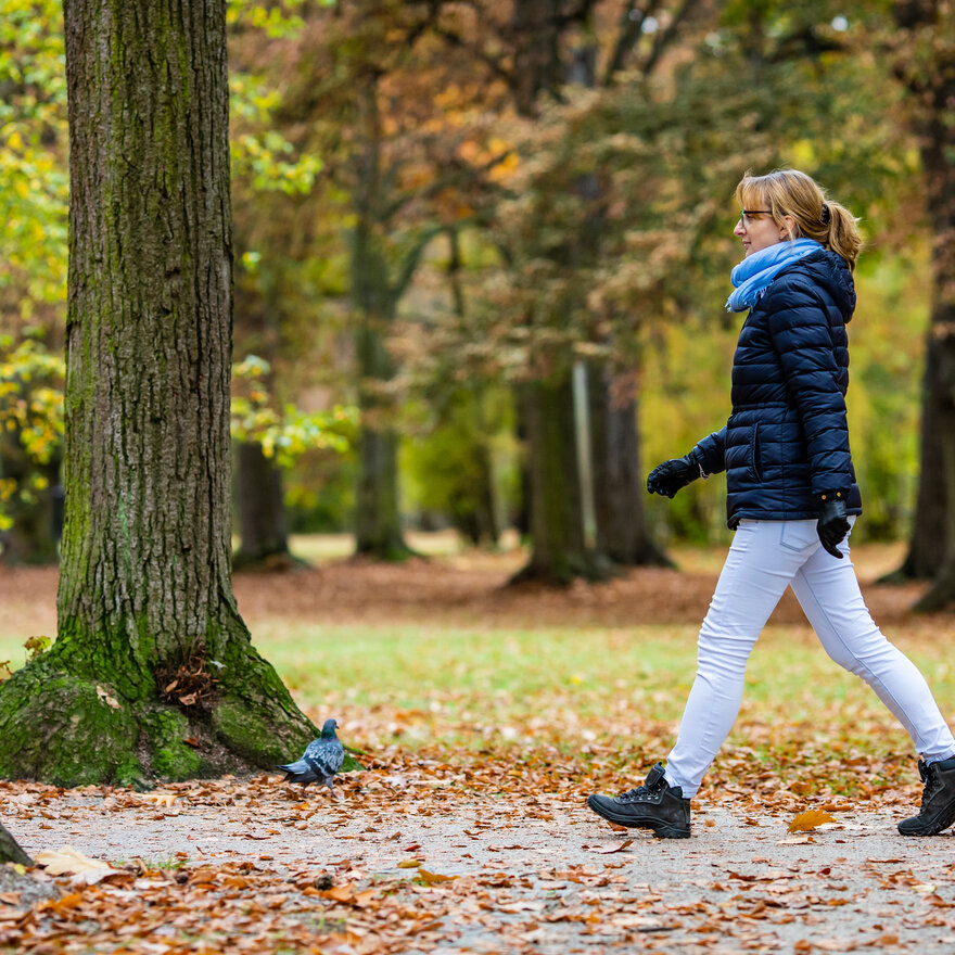 Woman walking alone in an urban park. 