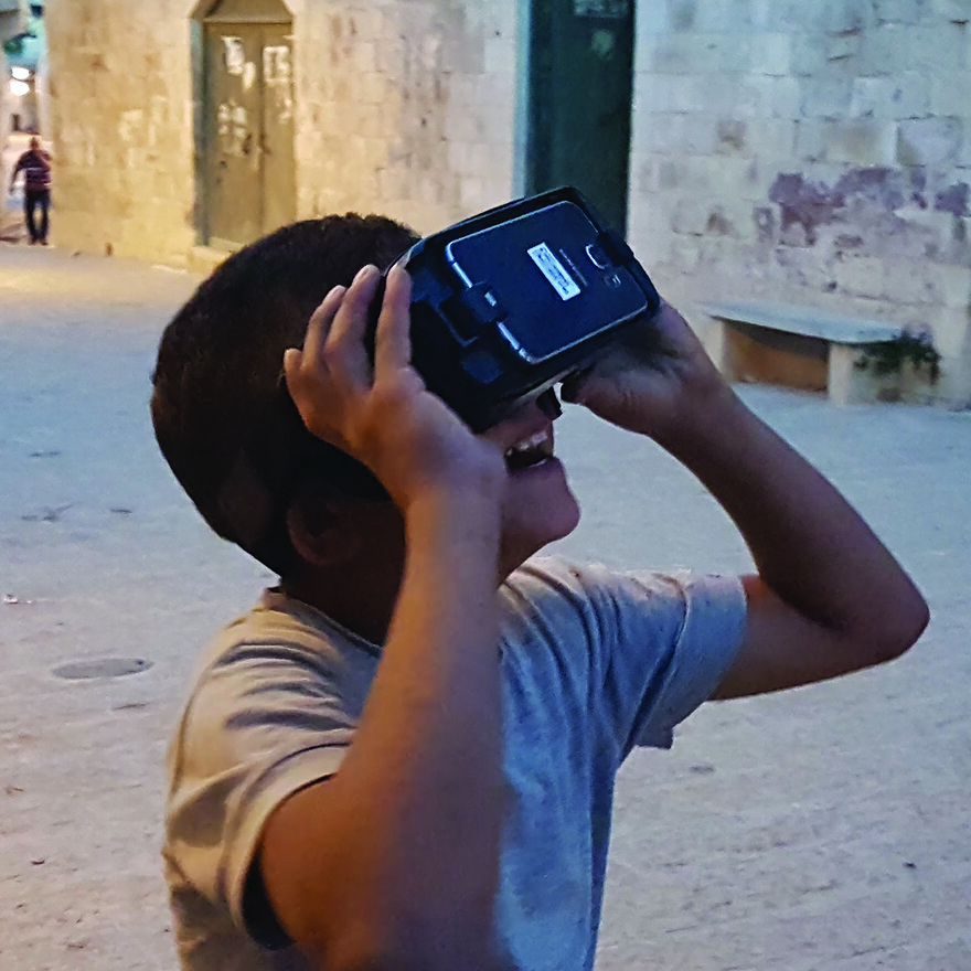 A child experiencing VR demonstrations of a heritage site in a workshop in Jenin, Palestine
