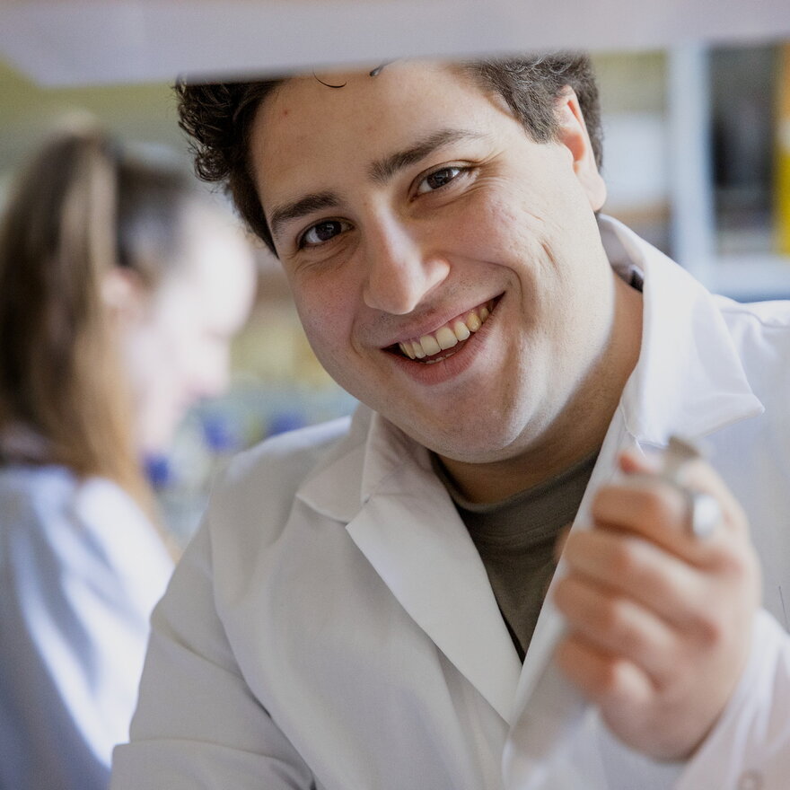 Studenter i forskning-prosjekt med student i lab.