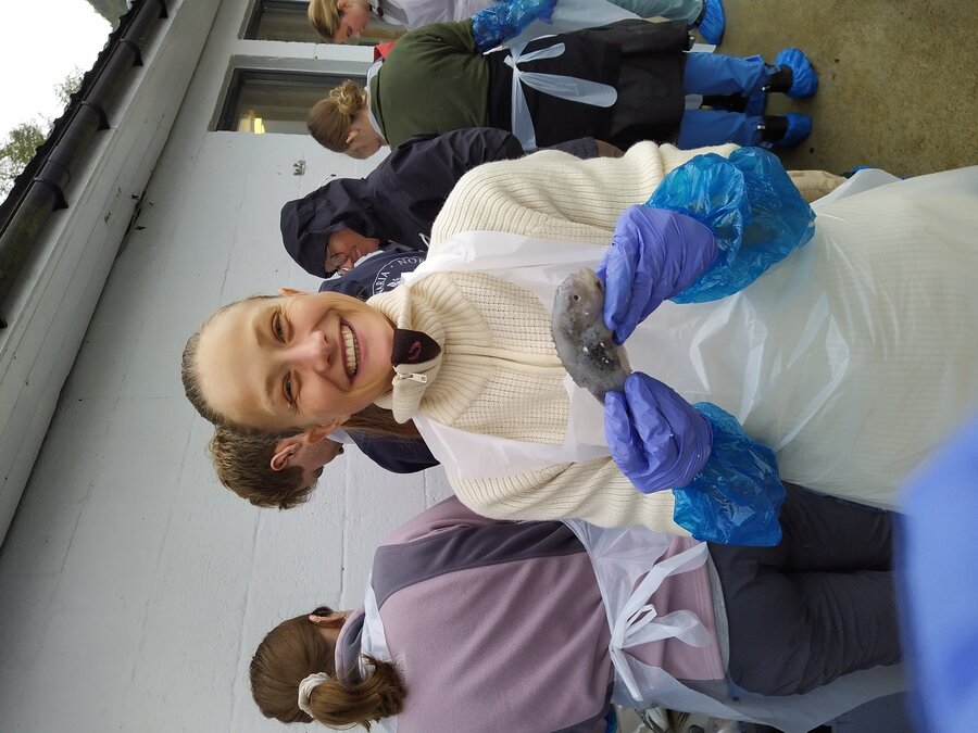 Veterinærstudent Ingeborg Kjønno Schaanning holder en liten fisk.