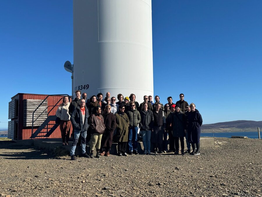 Empowered Futures research school members under a wind turbine at Burgar Hill, Orkney