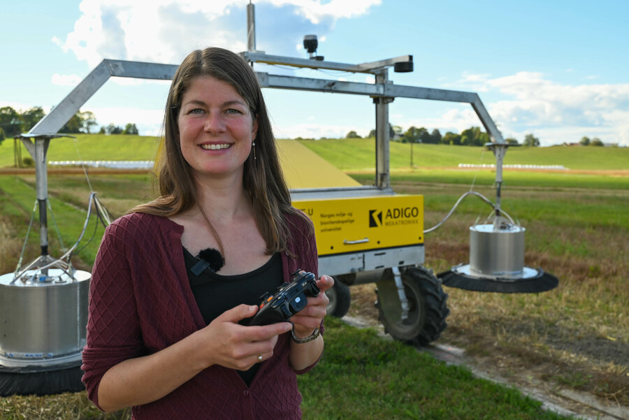 Stipendiat Elisabeth Gautefall Hiis under feltarbeid på Kjerringjordet i Ås, hvor forskerne bruker en robot utviklet av NMBU og Adigo til å måle lystgassutslipp fra jord. 
