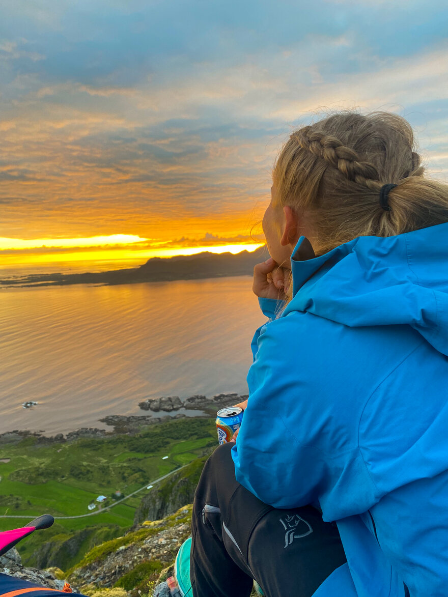 Bildet viser studentene som ser ut over solnedgangen fra et utkikkspunkt oppe i fjellet. Langt der nede kan man se hav og grønne sletter.